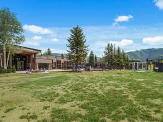 Experience the ultimate mountain getaway at this stunning property, featuring a modern lodge with ample seating and a cozy fire pit perfect for evening relaxation.