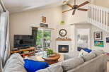 Step into this inviting living room featuring a cozy fireplace and a large sliding glass door that opens to a lush outdoor space.