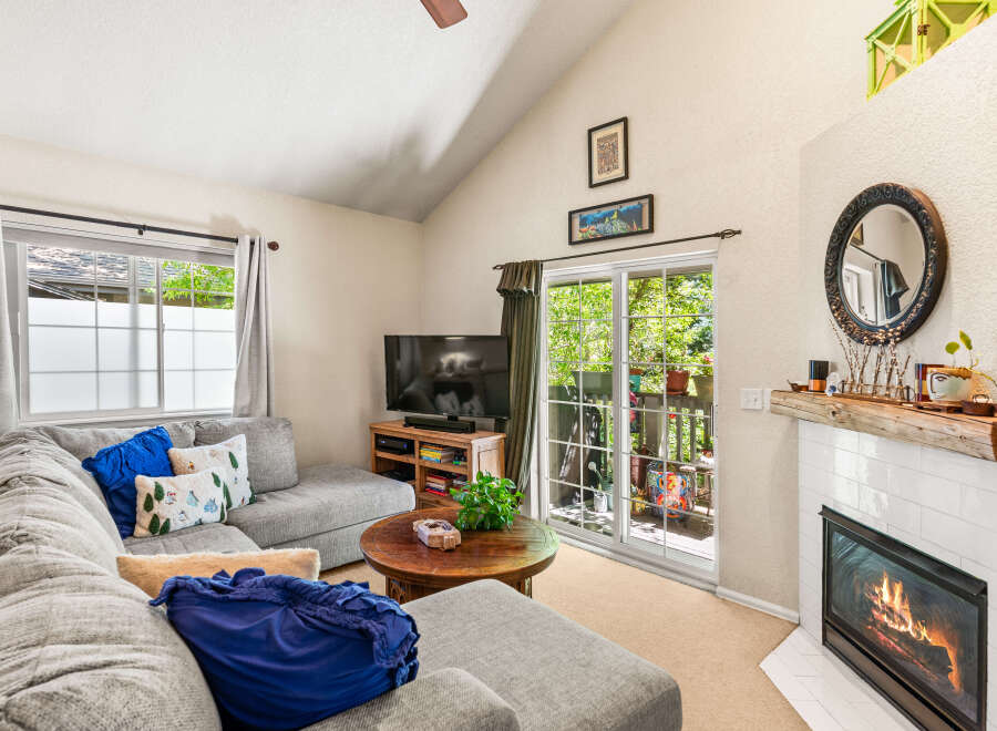 Cozy living room featuring a plush sectional sofa adorned with decorative pillows, a rustic wooden coffee table, and a modern entertainment center with a flat-screen TV.