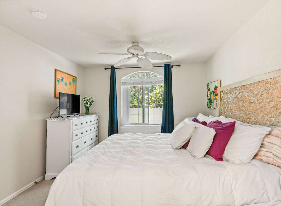 This charming bedroom features a comfortable queen-size bed adorned with plush pillows and a white duvet, perfect for relaxation.