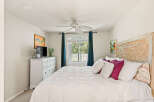 This charming bedroom features a comfortable queen-size bed adorned with plush pillows and a white duvet, perfect for relaxation.