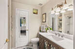 This charming bathroom features a spacious vanity with a marble countertop and a modern sink, complemented by elegant brass fixtures.