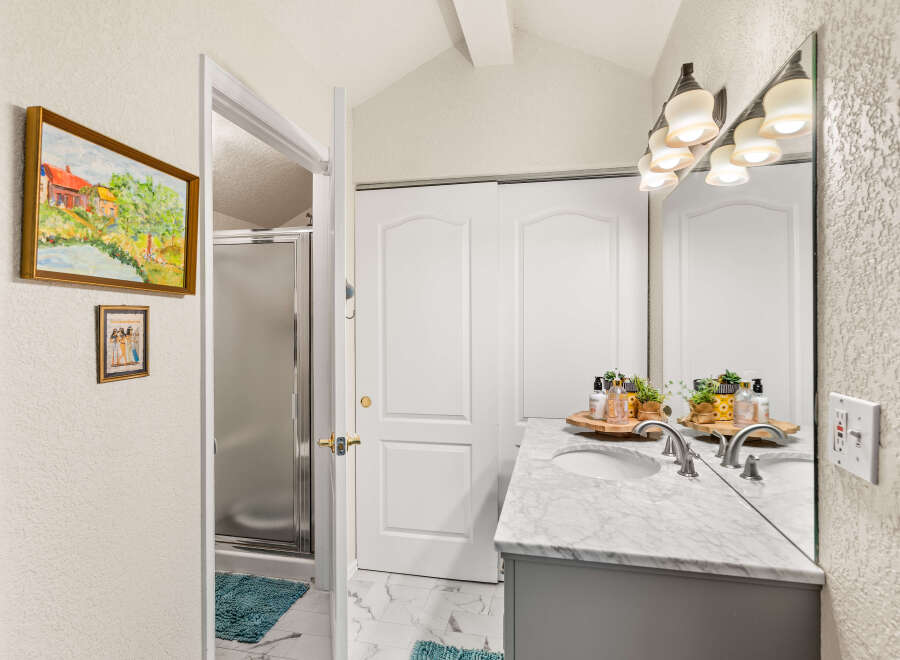 This bathroom features a spacious vanity with a marble countertop and dual sinks, perfect for busy mornings.