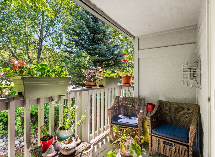 Enjoy your morning coffee on this charming balcony, surrounded by lush greenery and vibrant flowers.