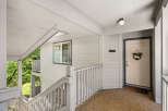 Welcome to this charming property featuring a welcoming front porch with a white railing and a light-colored door.