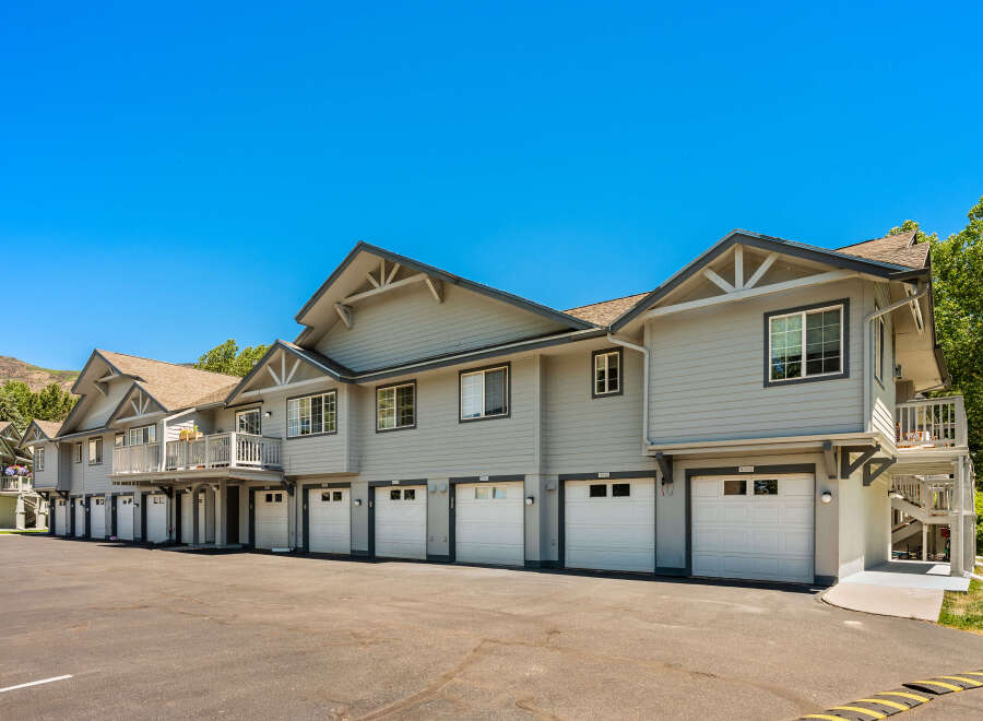 Discover modern living in this stunning townhome complex, featuring a row of attached garages with white doors and individual unit numbers.
