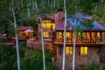 Nestled amidst a serene aspen grove, this stunning stone-clad mountain home offers luxurious living with breathtaking natural surroundings.