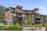 Experience modern mountain living in this stunning condo complex, featuring a striking architectural design with natural wood accents and stone detailing.