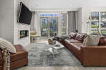 Experience modern living in this stylish living room featuring a sleek fireplace and a large leather sectional.