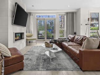 Experience modern living in this stylish living room featuring a sleek fireplace and a large leather sectional.