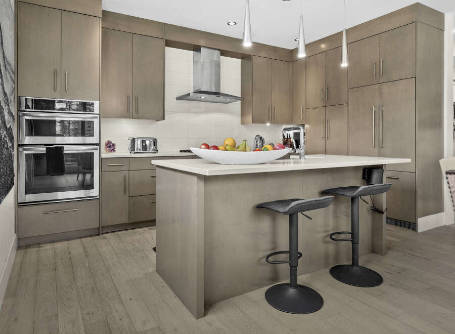 Experience modern luxury in this stunning kitchen, featuring sleek, taupe cabinetry and a spacious island perfect for entertaining.