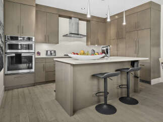 Experience modern luxury in this stunning kitchen, featuring sleek, taupe cabinetry and a spacious island perfect for entertaining.