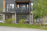 Experience modern mountain living in this stunning property featuring a sleek facade with stone and wood accents.