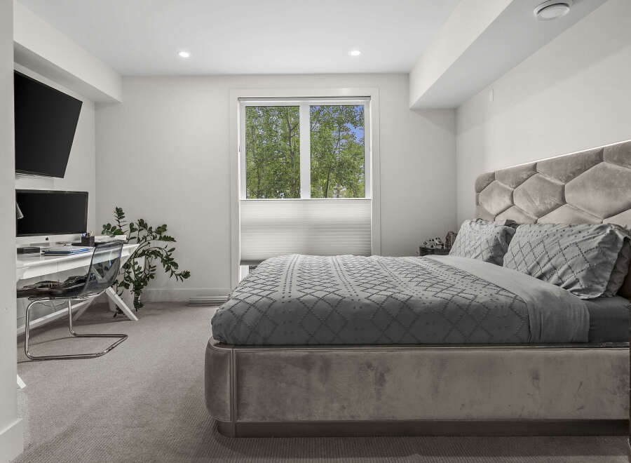 Experience modern comfort in this stylish bedroom, featuring a plush velvet headboard with integrated lighting and a luxurious grey duvet set.