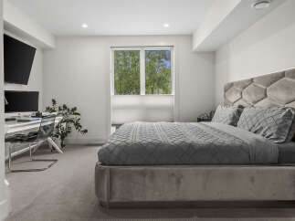 Experience modern comfort in this stylish bedroom, featuring a plush velvet headboard with integrated lighting and a luxurious grey duvet set.