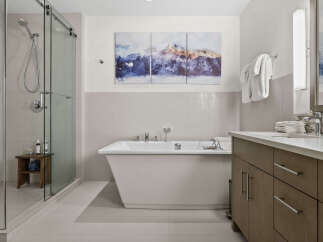 Experience modern luxury in this stunning bathroom, featuring a sleek freestanding bathtub and a spacious glass-enclosed shower.
