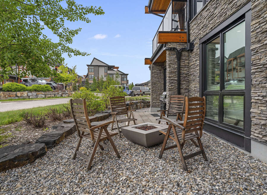 Enjoy outdoor living with this charming patio featuring a modern fire pit and comfortable seating.