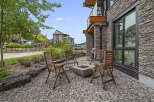 Enjoy outdoor living with this charming patio featuring a modern fire pit and comfortable seating.