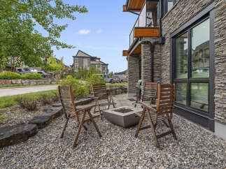 Enjoy outdoor living with this charming patio featuring a modern fire pit and comfortable seating.