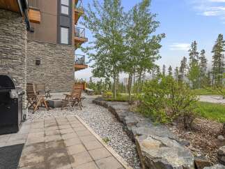 Enjoy outdoor living with this charming patio featuring a gas grill and a cozy fire pit area, perfect for entertaining.