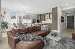 Experience modern living in this stunning open-concept condo, featuring a spacious living area with a luxurious leather sectional and a sleek, contemporary kitchen perfect for entertaining.