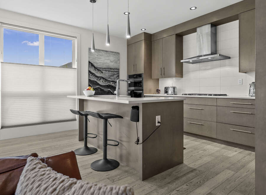 Experience modern luxury in this stunning kitchen featuring sleek, grey cabinetry and a spacious island perfect for entertaining.