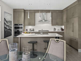 Experience modern luxury in this stunning kitchen, featuring sleek, taupe cabinetry and a spacious quartz island perfect for entertaining.