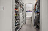 Step into this spacious walk-in closet, featuring ample shelving and drawers for organized storage.
