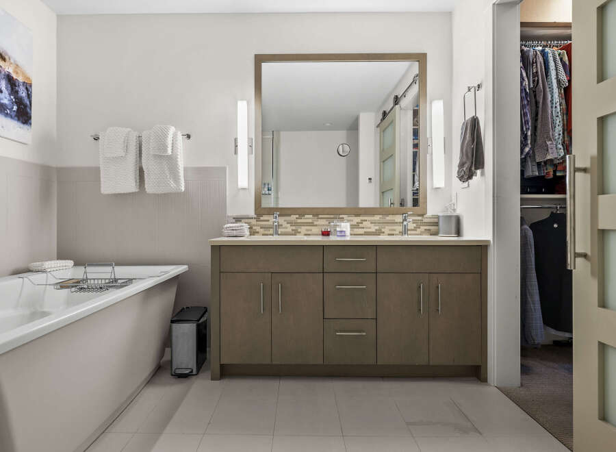 Experience luxury and convenience in this stunning bathroom featuring a deep soaking tub and a spacious double vanity with ample storage.