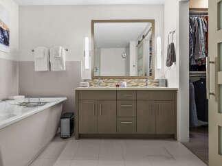 Experience luxury and convenience in this stunning bathroom featuring a deep soaking tub and a spacious double vanity with ample storage.