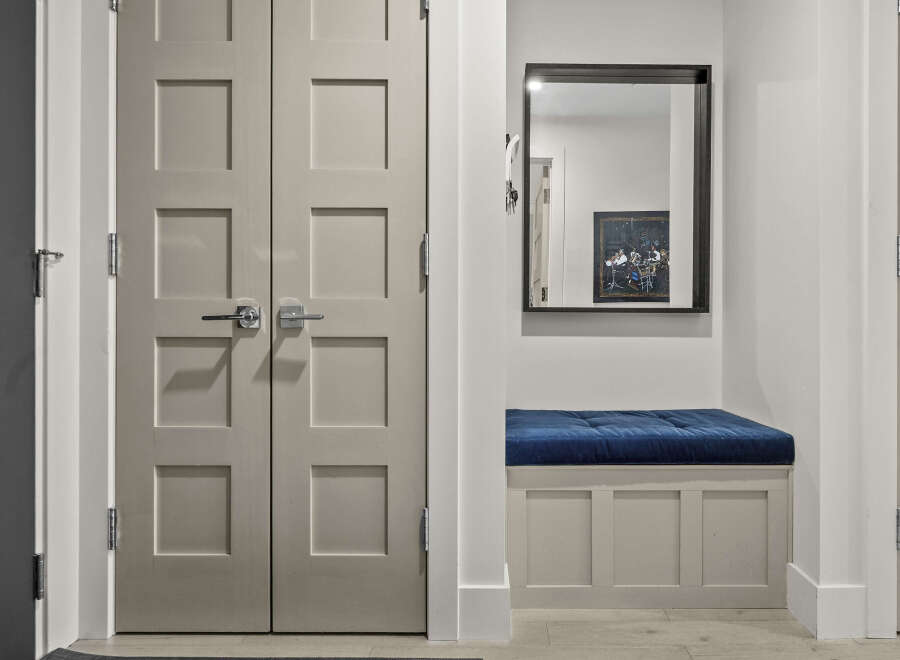 Step into a welcoming entryway featuring a stylish bench with a plush blue cushion, perfect for putting on shoes.