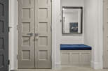 Step into a welcoming entryway featuring a stylish bench with a plush blue cushion, perfect for putting on shoes.