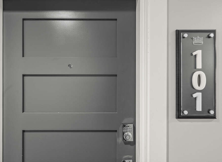 Discover modern living with this sleek, gray paneled door featuring a digital keypad lock for enhanced security.