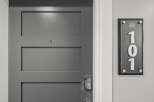 Discover modern living with this sleek, gray paneled door featuring a digital keypad lock for enhanced security.