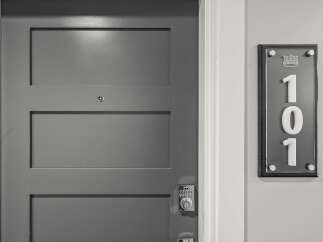 Discover modern living with this sleek, gray paneled door featuring a digital keypad lock for enhanced security.