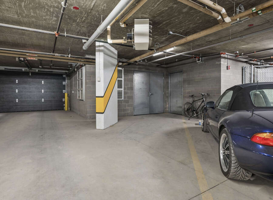 Discover secure and convenient parking in this spacious garage, featuring a sleek black overhead door and ample room for your vehicles.