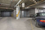 Discover secure and convenient parking in this spacious garage, featuring a sleek black overhead door and ample room for your vehicles.