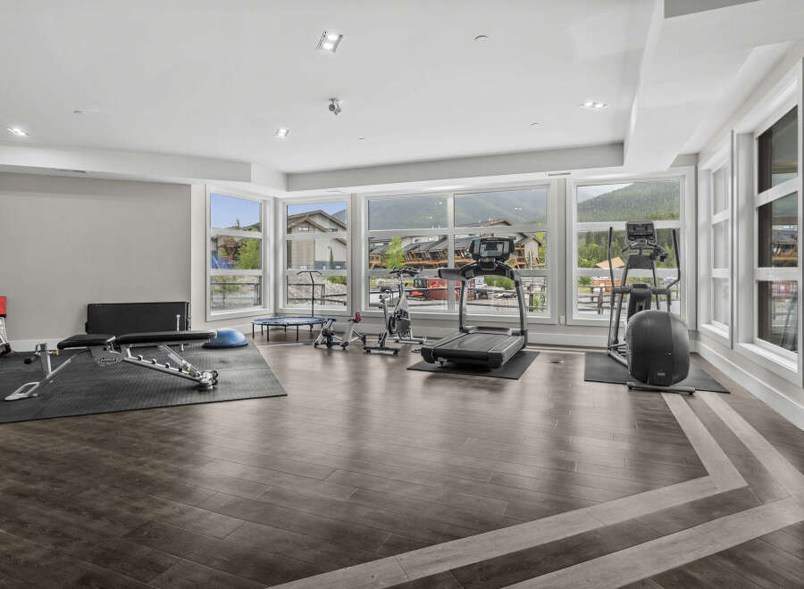 This spacious home gym features a variety of cardio and strength training equipment, including treadmills, stationary bikes, and a weight bench.