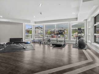 This spacious home gym features a variety of cardio and strength training equipment, including treadmills, stationary bikes, and a weight bench.