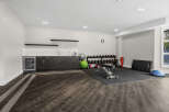 This modern home gym features a comprehensive dumbbell rack, an adjustable weight bench, and a variety of exercise balls for a complete workout.