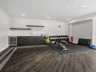 This modern home gym features a comprehensive dumbbell rack, an adjustable weight bench, and a variety of exercise balls for a complete workout.