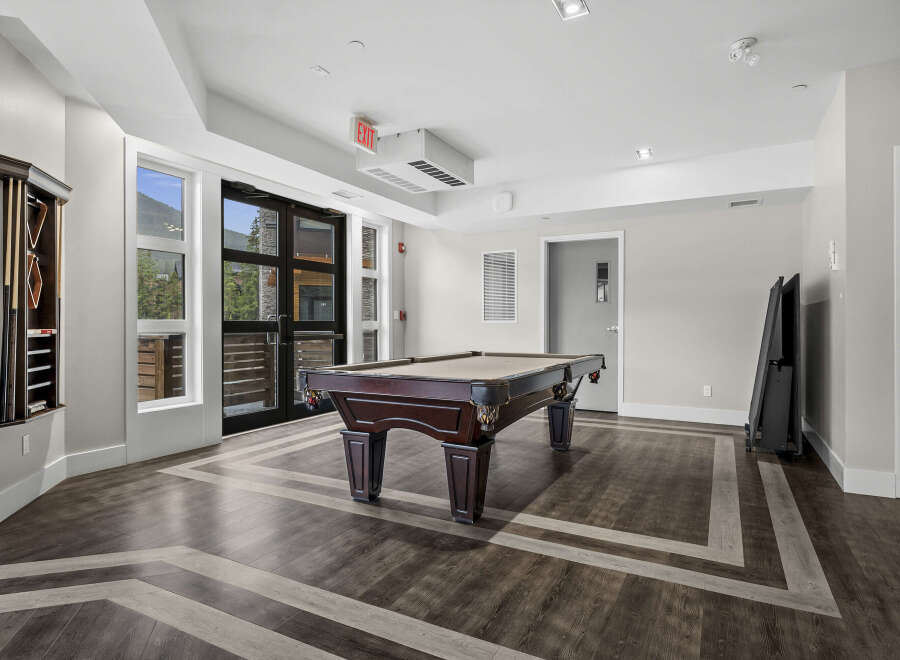 Enjoy endless entertainment in this stylish game room, featuring a classic billiard table perfect for friendly competitions.