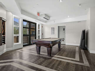 Enjoy endless entertainment in this stylish game room, featuring a classic billiard table perfect for friendly competitions.