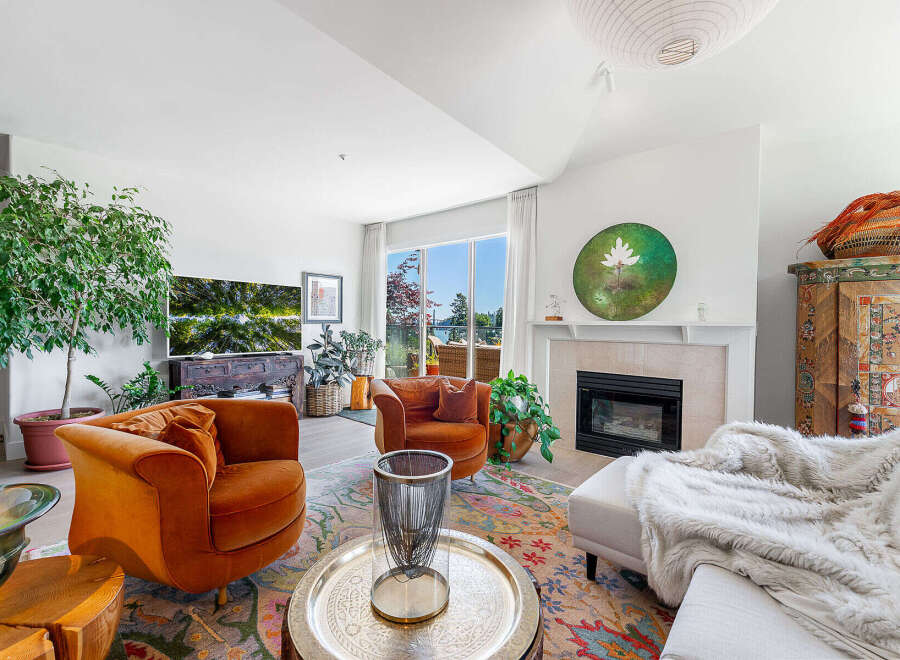 Experience luxurious living in this stunning living room, featuring plush velvet armchairs and a cozy fireplace.