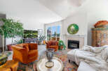 Experience luxurious living in this stunning living room, featuring plush velvet armchairs and a cozy fireplace.