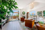 Experience luxurious living in this stunning apartment, featuring a spacious living area with a cozy fireplace and large windows that open to a private balcony with water views.