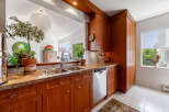 Discover this charming kitchen featuring warm cherry wood cabinetry and elegant granite countertops.