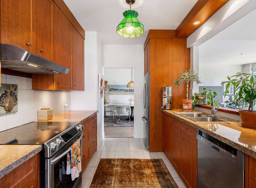 This charming kitchen features warm cherry wood cabinetry and granite countertops, offering a sophisticated and inviting atmosphere.