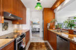 This charming kitchen features warm cherry wood cabinetry and granite countertops, offering a sophisticated and inviting atmosphere.