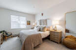 Discover this inviting bedroom featuring a plush quilted bedspread and a cozy armchair, perfect for relaxation.